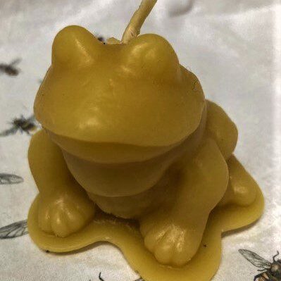 Yellow frog candle with fly pattern background